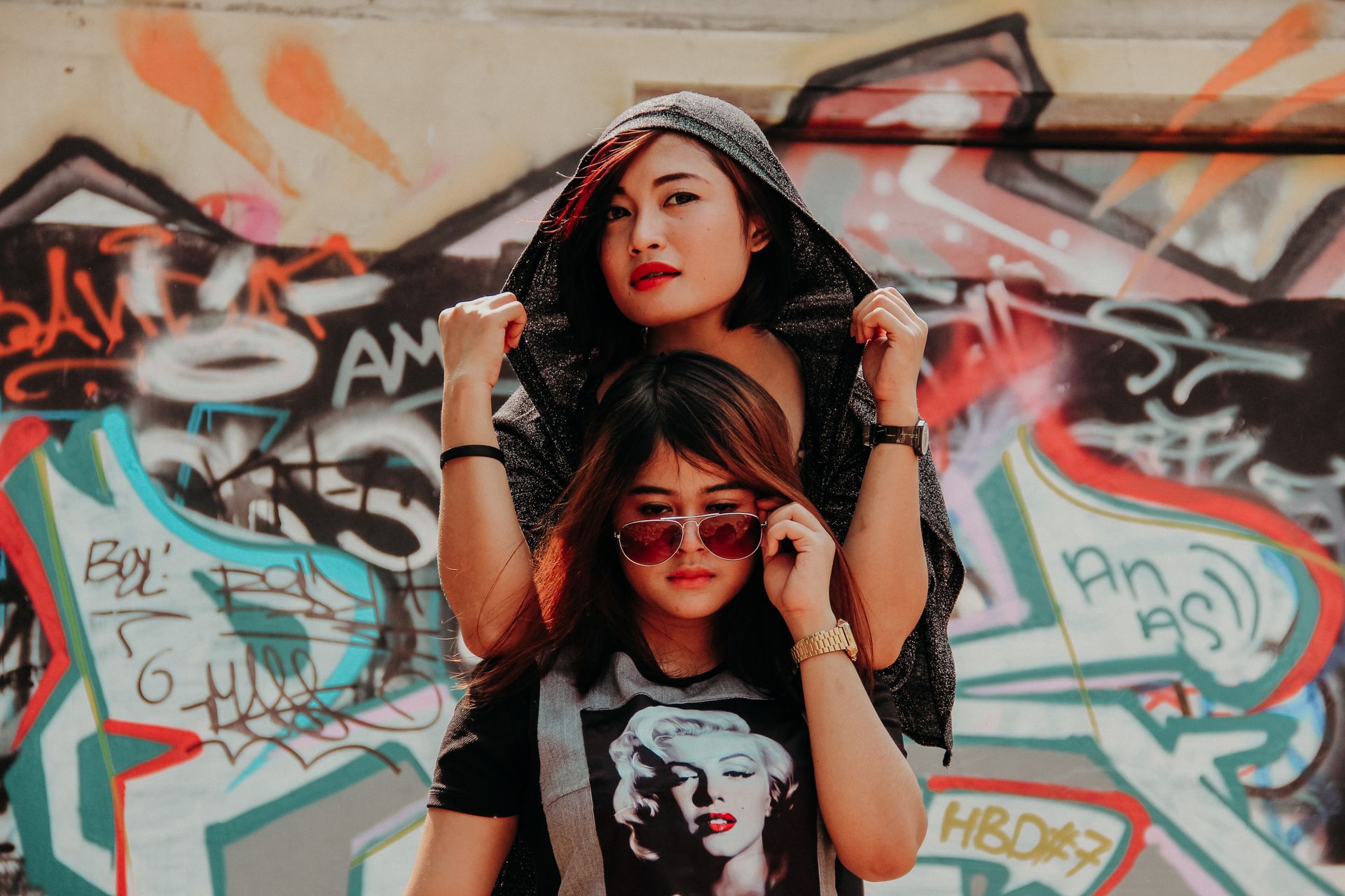 Women posing on a graffiti wall
